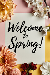 Kaligraficzny napis „Welcome to Spring!” na białej kartce, udekorowanej wokół jasnymi i bordowymi kwiatami oraz kwitnącymi gałązkami na różowo-żółtym tle. © Silent26
