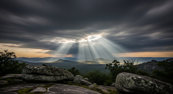 Dramatic Sun Rays Breaking through Dark Clouds over Rocky Mountain Landscape