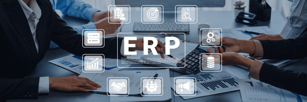 A professional business team engages in an enterprise resource planning session, analyzing data and collaborating on strategies with digital tools and financial documents present on the table. Ledger