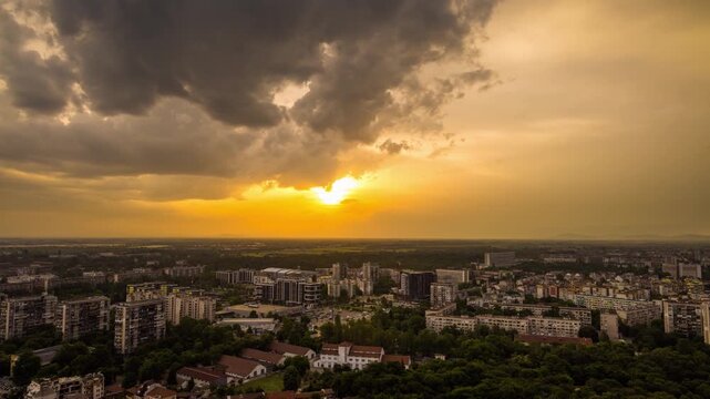 Town Plovdiv with houses and fields against backdrop of Rhodope Mountains and hills covered with forests and cloudy sky