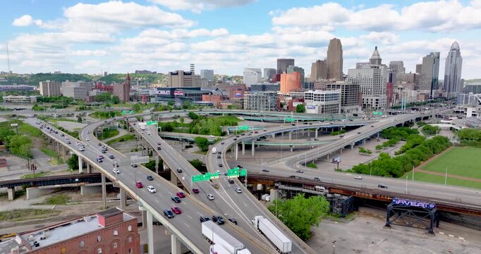 Aerial view of the Cincinnati skyline and busy highway interchange with traffic under a blue sky with clouds, Cincinnati, Ohio, United States.