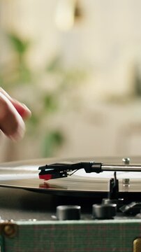 Retro Vinyl record player playing music, close-up macro shot of vintage LP disc old phonograph spinning. Retro music player at home.