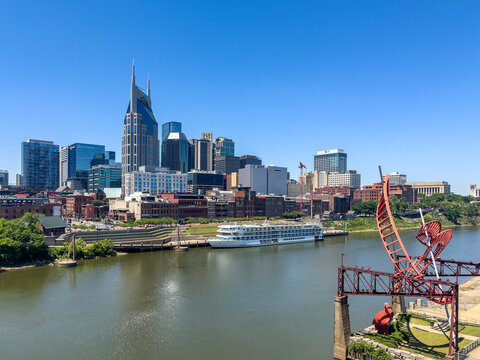 The Nashville, Tennessee, skyline as seen from across the Cumberland River with the American Symphony Cruise Ship and the Ghost Ballet for the East Bank Machineworks sculpture in the foreground