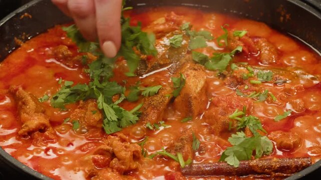Cooking chicken Indian curry, tikka masala, chicken, lamb, mutton Rogan Josh grill boiling on pan, sauce. Dark background. Close up.