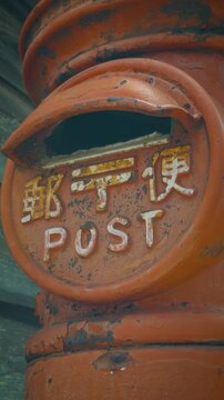 Extreme close-up of an old rusted vintage red post box in Japan with traditional kanji letters