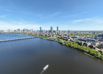 Obraz premium Panoramic aerial drone view of Boston Back Bay skyline, Prudential Tower, and Charles River Esplanade on a clear summer day, featuring historic brownstones and city skyscrapers, USA.