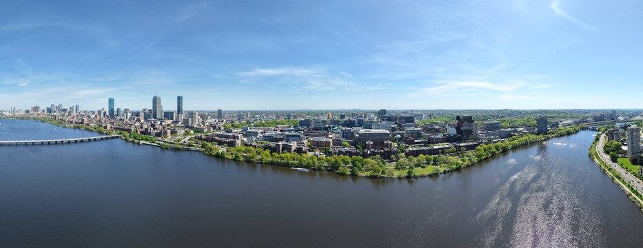 Panoramic aerial drone view of Boston Back Bay skyline, Prudential Tower, and Charles River Esplanade on a clear summer day, featuring historic brownstones and city skyscrapers, USA.