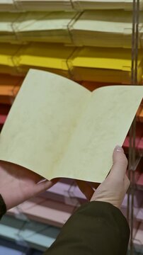 Hands Selecting and Reading Colorful Greeting Card in Gift Shop