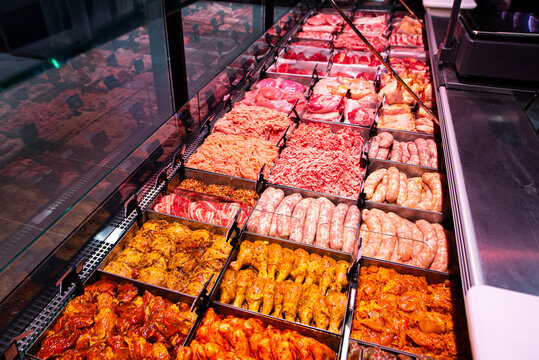 Supermarket meat counter with marinated barbecue meat, shashlik, lula kebab, grill sausages, and minced meat ready for cooking.