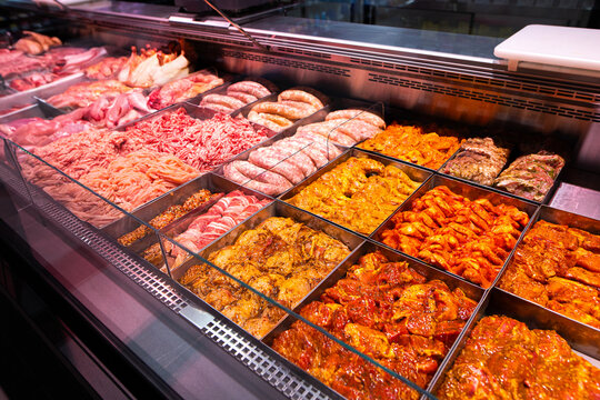 Supermarket meat counter with marinated barbecue meat, shashlik, lula kebab, grill sausages, and minced meat ready for cooking.