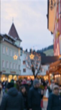Blurred Christmas Market Crowd Walking Through Festive Holiday Lights
