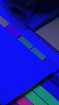 Taking paper from notebooks with colored page tabs.
