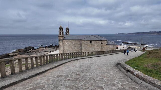 Santuario da virxe da barca church with pilgrims walking along the path by the atlantic ocean