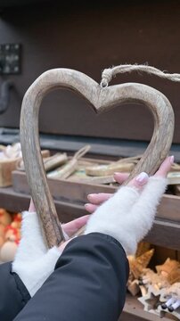 Close Up Hands Choosing Wooden Heart Decoration at Christmas Market