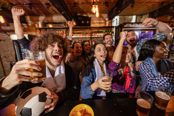 Fototapeta premium Joyful sports fans lifting hands and beers in celebration of a football goal victory.