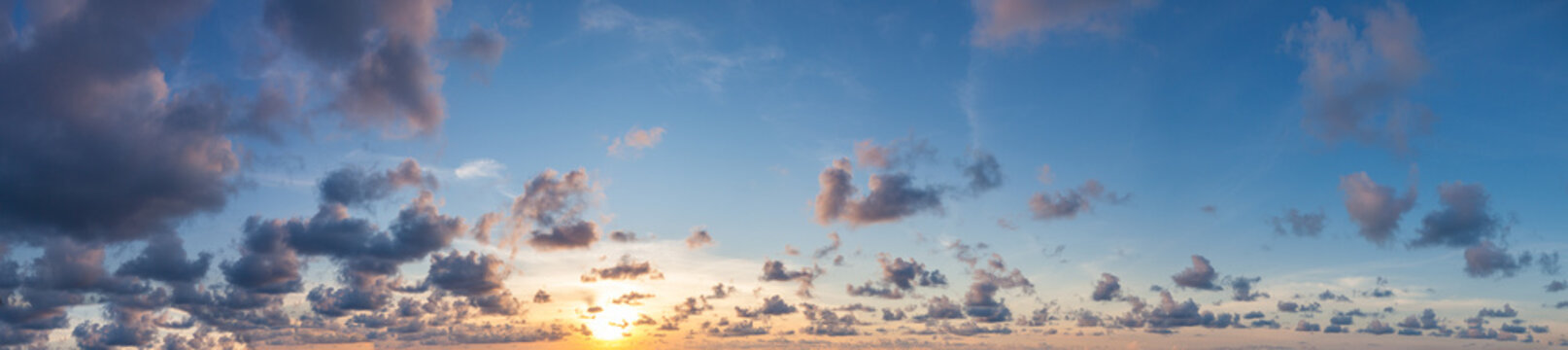 Cielo oscuro y dram&aacute;tico con un resplandor de atardecer. Paisaje panor&aacute;mico de nubes oscuras que contrastan con un brillante horizonte anaranjado de atardecer.