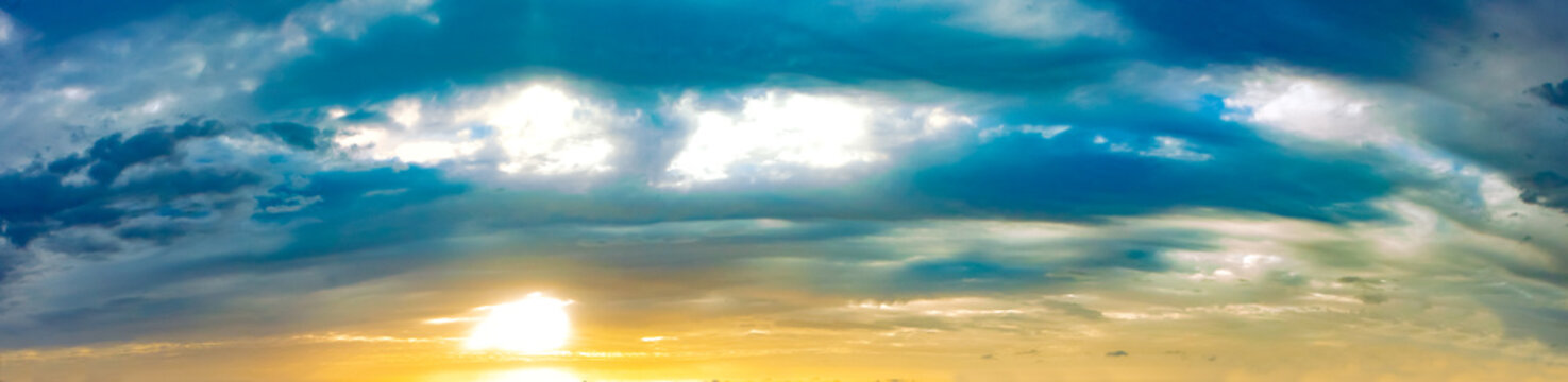 Espectacular panorama de una puesta de sol dorada con nubes brillantes en capas. Una rica puesta de sol panor&aacute;mica con m&uacute;ltiples capas de nubes ba&ntilde;adas en tonos dorados, &aacute;mbar y turquesa.