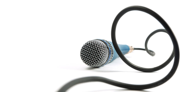 Micr&oacute;fono din&aacute;mico azul con cable sobre fondo blanco en un estudio. Concepto de radio y m&uacute;sica. Micr&oacute;fono din&aacute;mico profesional con acabado azul y cable negro en espiral sobre un fondo blanco impecable