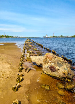 Old Wooden Groin Breakwater and Stone Pier Remaining on Sandy River Bank Shoreline &mdash; Coastal Erosion Control, Historic Maritime Infrastructure, and River Estuary Waterway Riga Kipsala