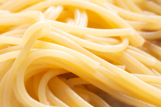 湯気立つスパゲッティの束が絡み合う、調理直後のパスタ