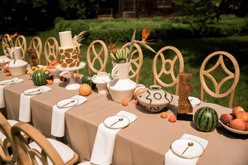 Elegant destination wedding table with safari chic styling tropical botanicals and contemporary artisan decor beside tranquil water © Nele