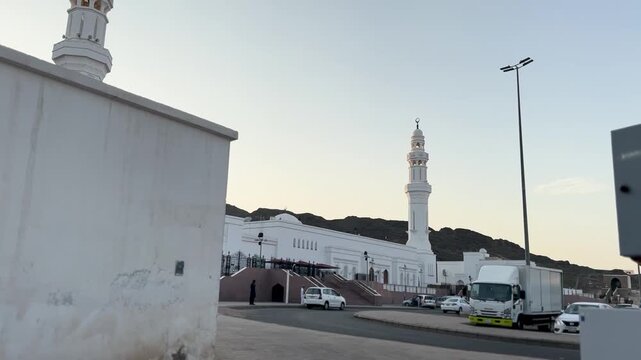 A beautiful panning shot of the historic white Al Fath Mosque (Masjid Al Fath) in Medina, Saudi Arabia, set against Mount Sila.