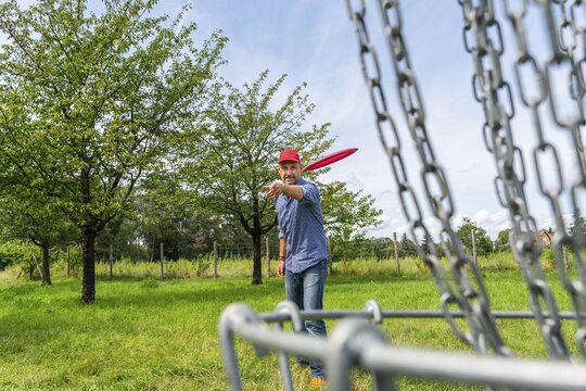 Man throwing a disc at Discgolf, also Disc Golf, Volkspark Potsdam, Potsdam, Brandenburg, Germany