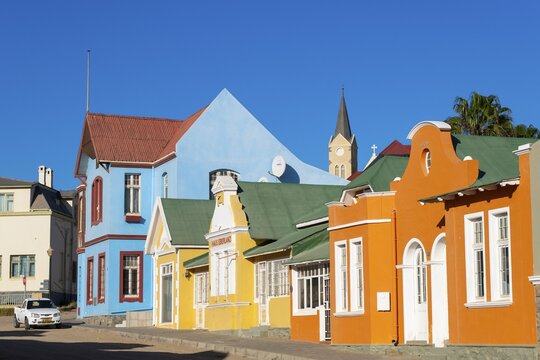 Colourful houses from German colonial times, behind the tower of the rock church, old town of L&uuml;deritz, Namibia