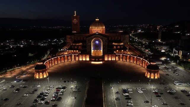 Night Catholic Temple In Aparecida Sao Paulo Brazil. Breathtaking Aerial View Of Famous Church In The City. Building Town Sky Illuminated Urban. Town Drone View Illuminated . Aparecida Sao Paulo.