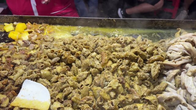Mexican street food vendor cooking tripas tacos