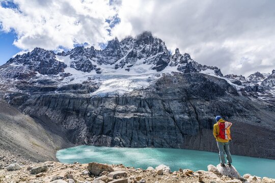 Hiker standing at the lagoon, glacial lake at Cerro Castillo mountain, Cerro Castillo National Park, Aysen, Patagonia, Chile