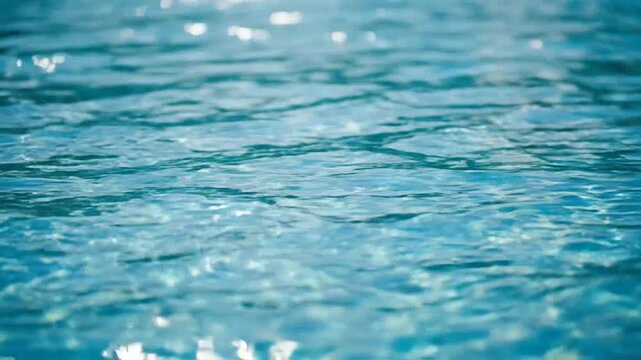 The gentle ripples of clear blue water shimmer under bright natural sunlight