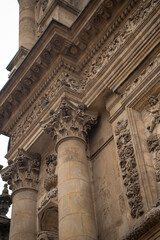 Obraz premium Vertical view of ancient baroque cathedral facade. Detailed stone carvings, columns and holy statues. Abstract historic european architecture background. High resolution 33MP. 