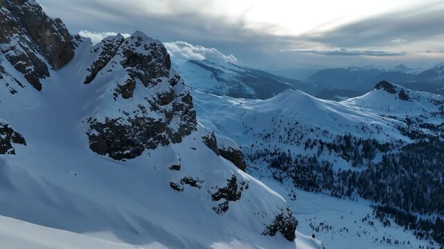 Aerial view of the snow-covered peaks and rocky cliffs of Parco Naturale Paneveggio Pale di San Martino in Primiero San Martino di Castrozza, Trentino-Alto Adige, Italy.