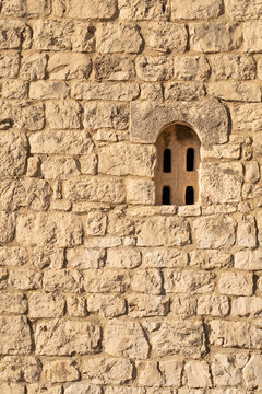 Ancient medieval stone wall texture with roman style arched window in Croatia
