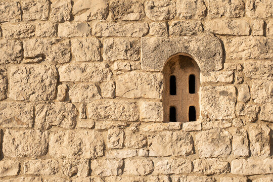 Ancient medieval stone wall texture with roman style arched window in Croatia
