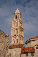 Fototapeta premium Epic Saint Domnius bell tower ancient Roman architecture vertical panorama. Cinematic low angle view of historic Diocletian palace limestone cathedral facade, terracotta roof tiles, Romanesque windo