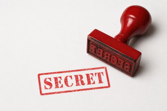 Red rubber stamp with SECRET text on white paper confidentiality concept minimalist flat lay