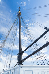 Obraz premium Sailboat Mast and ropes with cloudy blue sky background