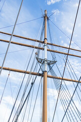 Obraz premium Sailboat Mast and ropes with cloudy blue sky background
