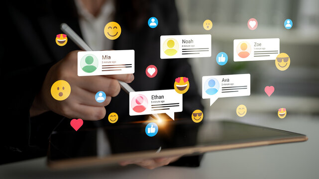 A person interacts with a tablet, showcasing virtual social media comments and reactions, creating a vibrant digital atmosphere in a modern workspace with emoji icons. Ledger
