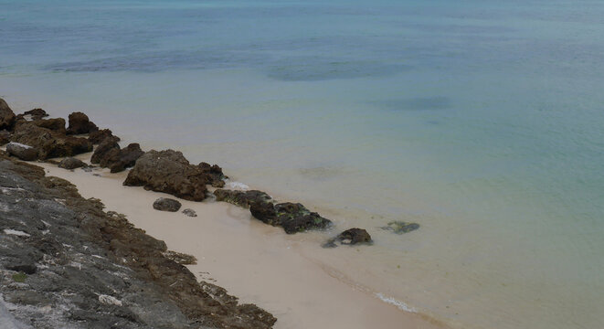 Coral rocks and white sand beside crystal clear 
turquoise water, Senaga Island, Tomigusuku, Okinawa, Japan
