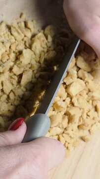 sbriciolare taralli locali pugliesi su di un tagliere con un coltello da cucina