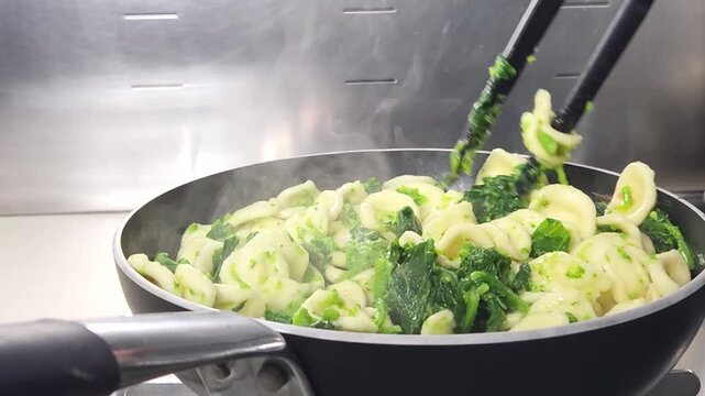 orecchiette con cime di rapa girate in una padella sul fuoco