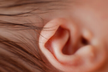 Fototapeta premium Caucasian Newborn baby ear closeup macro detail shot. child portrait, health skin, tenderness, maternity and babyhood concept - Image. Soft selective focus
