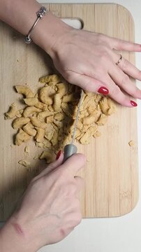 sbriciolare taralli locali pugliesi su di un tagliere con un coltello da cucina
