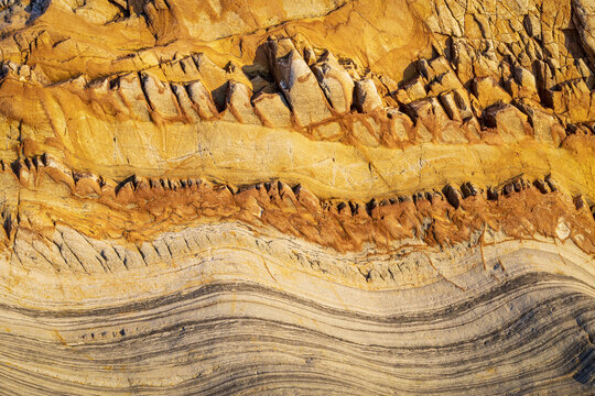 View of the unique geological rock formations and layered sedimentary textures at Silence Beach in Asturias, Asturias, Spain.