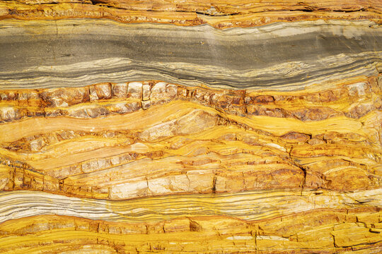 View of the geological rock formations and layered sediment at Silence Beach in Asturias, Asturias, Spain.