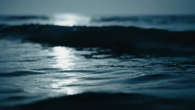 Abstract view of choppy, dark blue water with bright highlights of light