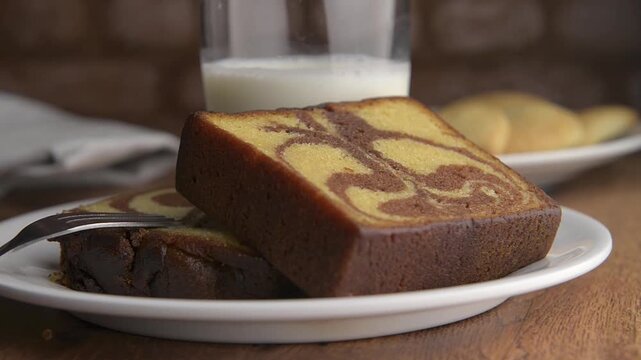 Fine pastries, Mexican sweet bread for breakfast, desserts, or family dinners, traditional. Close-up or zoom of bread. Marble cake with a glass of cold milk in the background